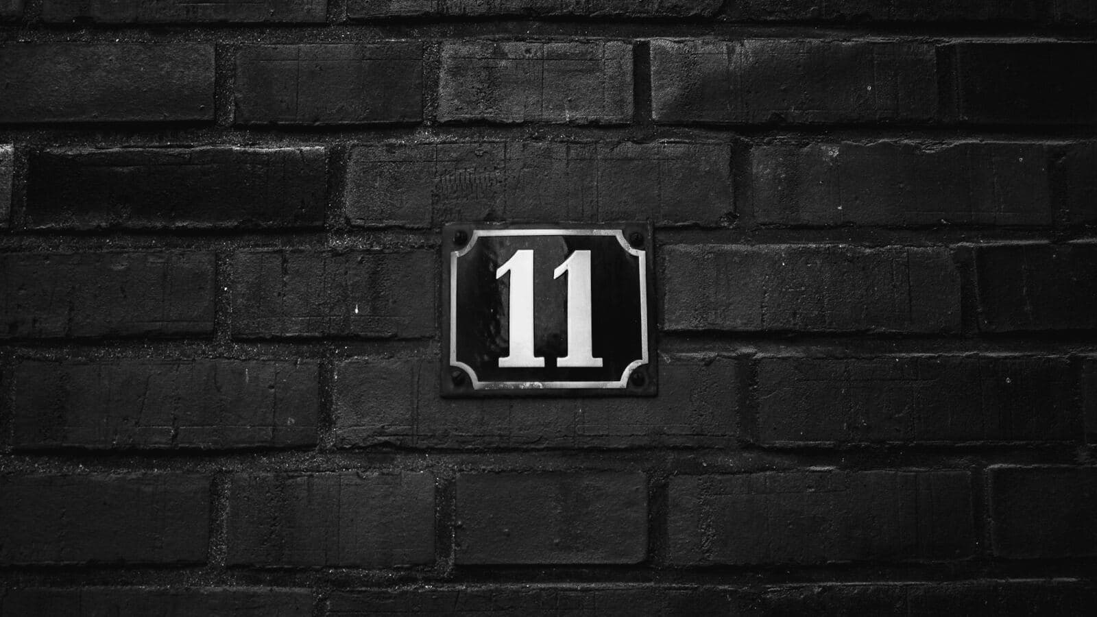 Una placa con el número 11 sobre ladrillo oscuro