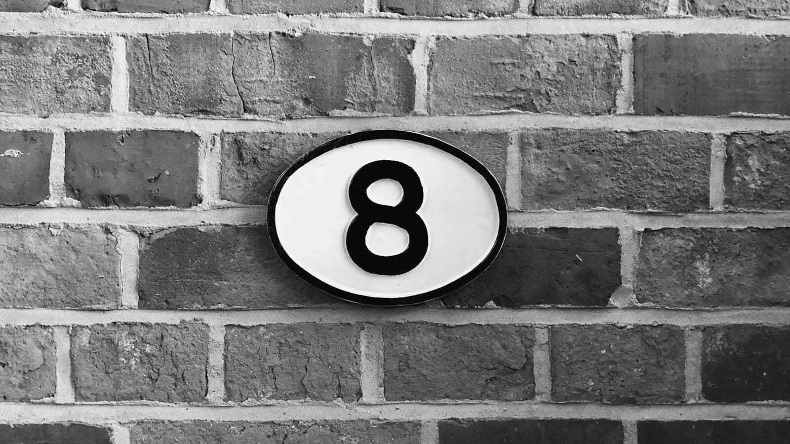 An oval plaque with the number 8 on brick